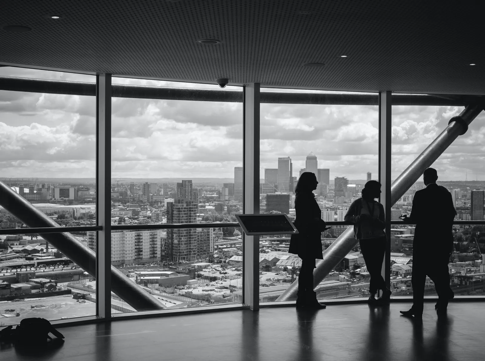 Silhouettes of business professionals overlooking a city skyline with Canary Wharf visible, representing institutional private equity