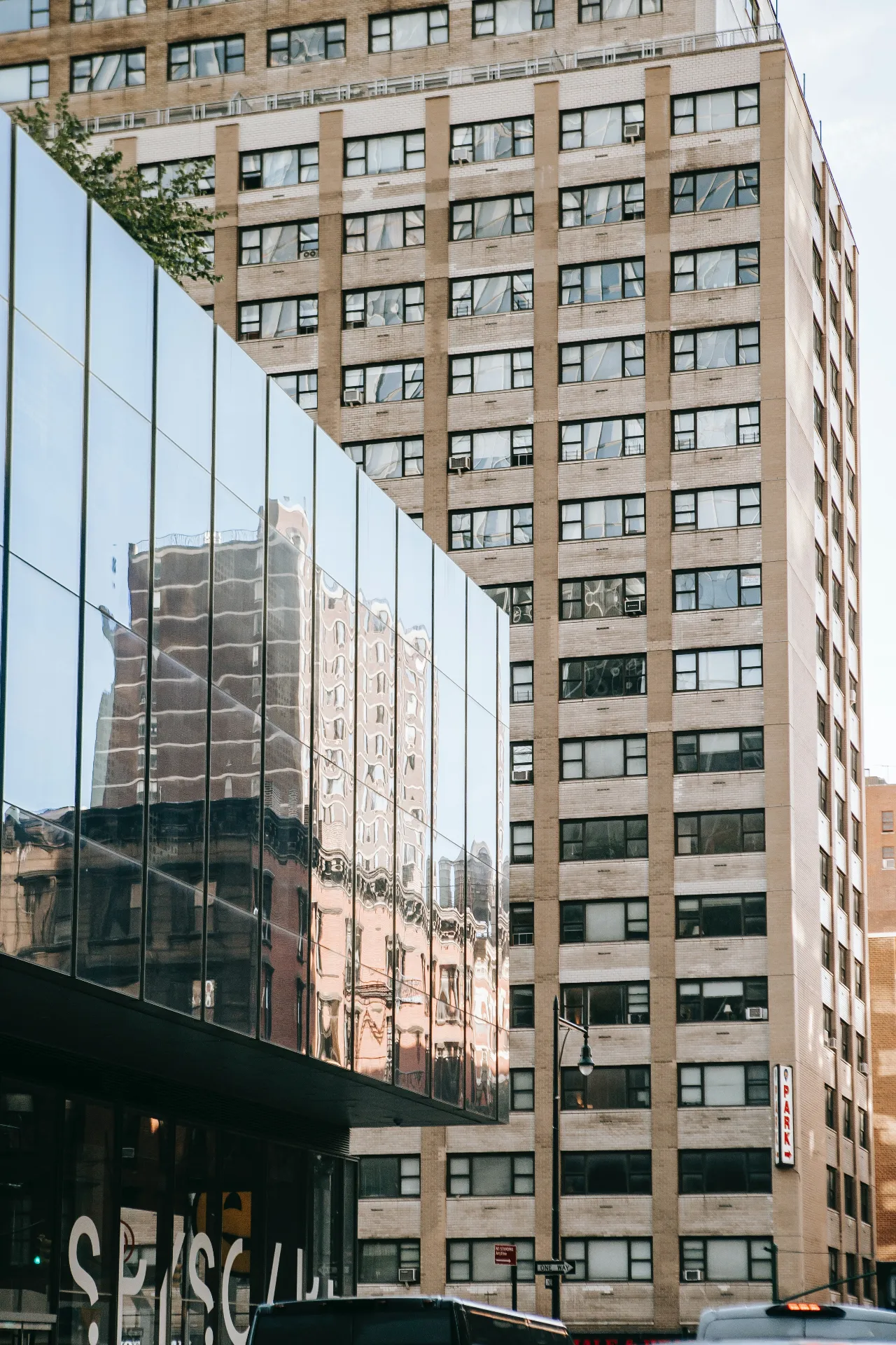Modern glass-fronted commercial building reflecting surrounding architecture