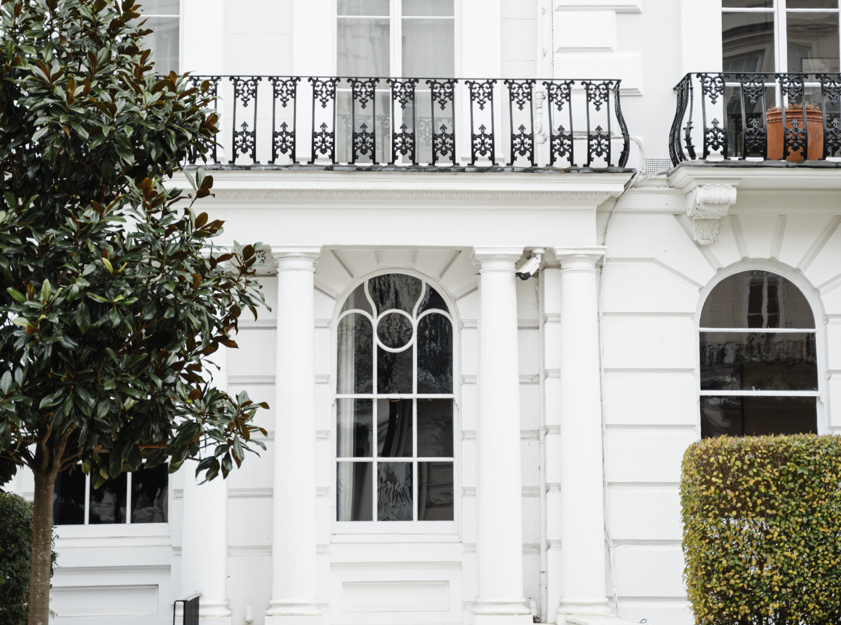 Elegant Georgian townhouse facade in London with wrought-iron balcony and columns